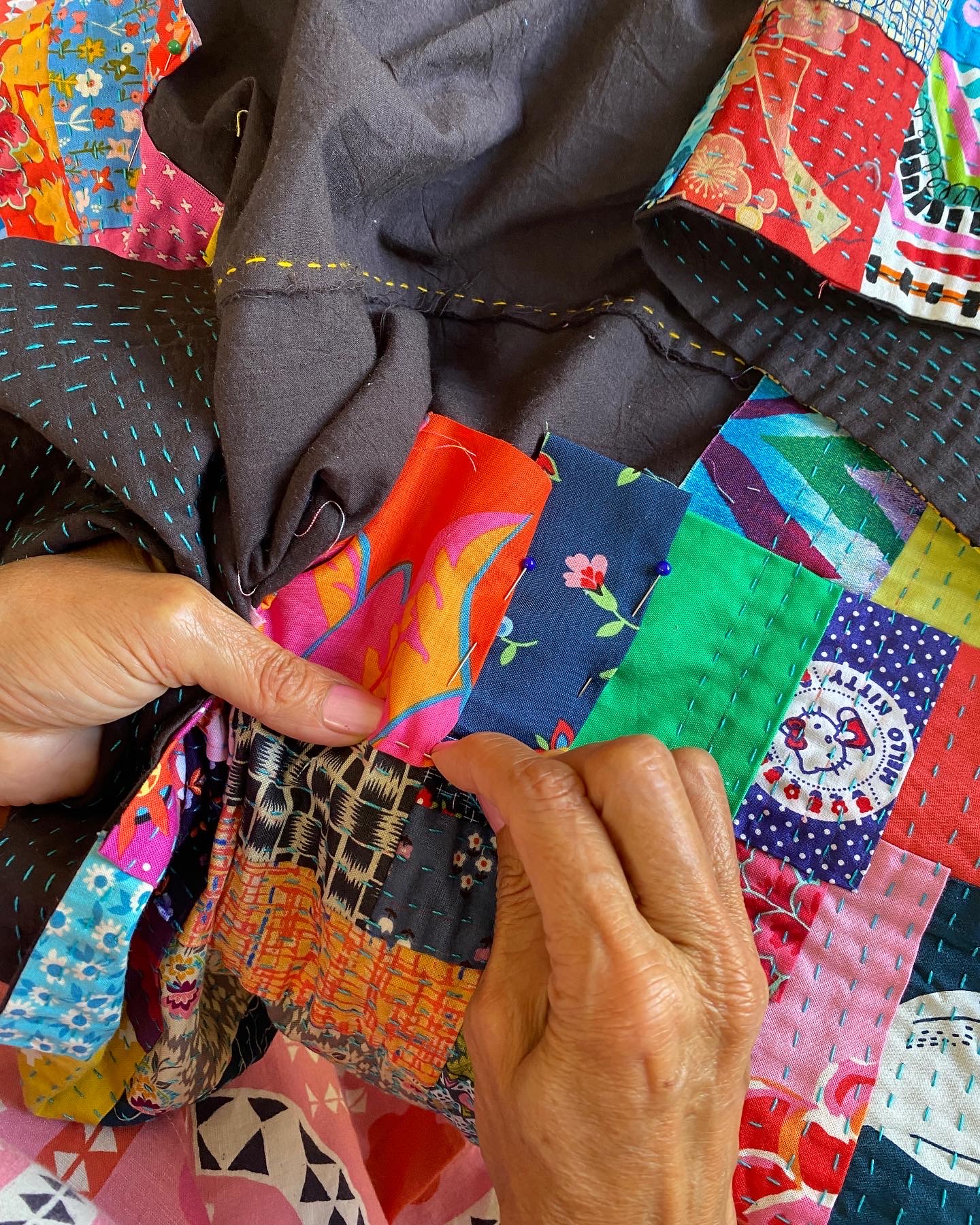 Lorena stitches kawandi with bright colourful fabrics.